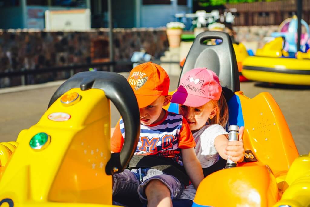 Chłopiec i dziewczyna jeżdżą na Bumper Cars w Parku Rozrywki.