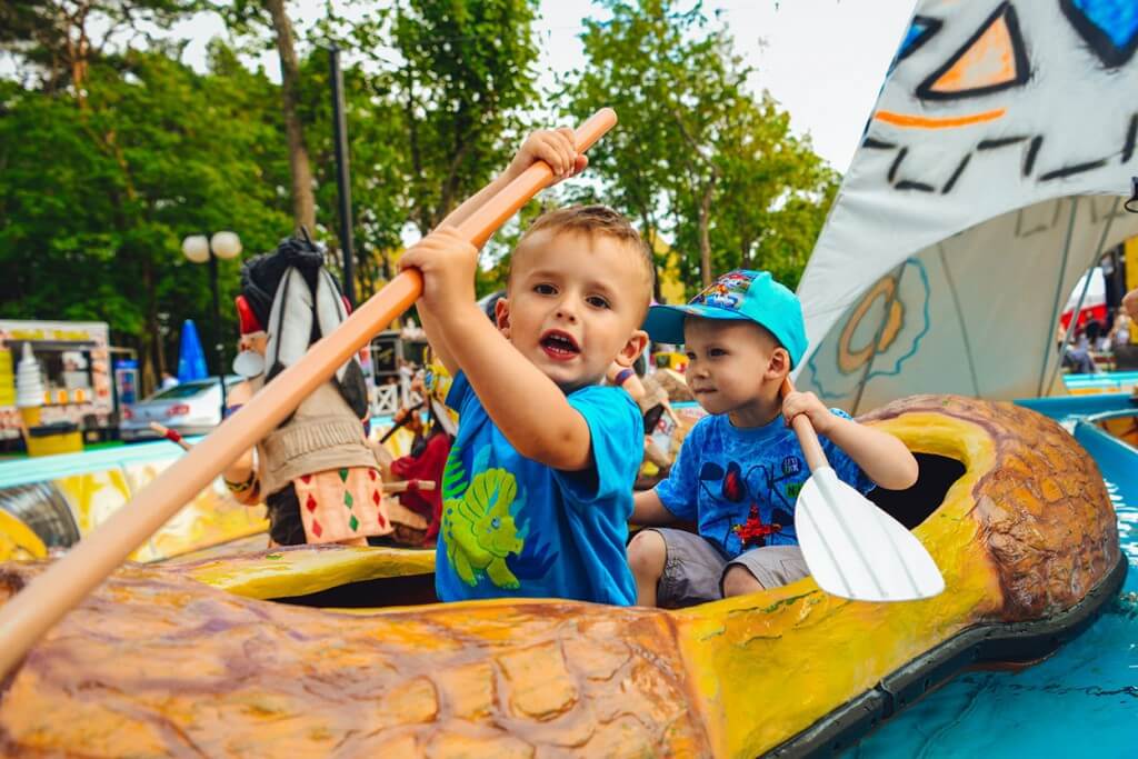 Zadowolone dzieci pływają łódeczkami kanu